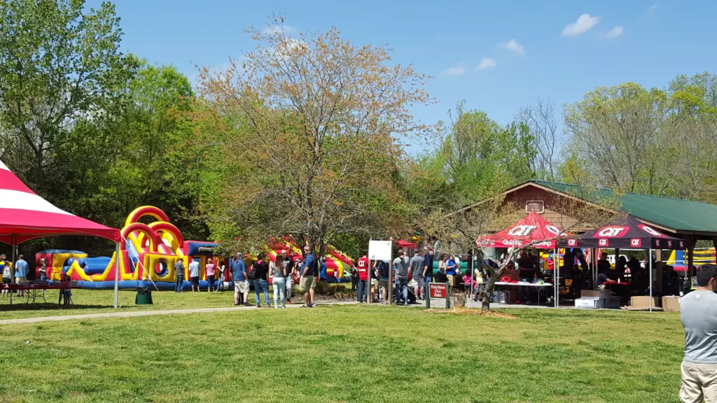 Tents and inflatables set up near a park shelter for a community event