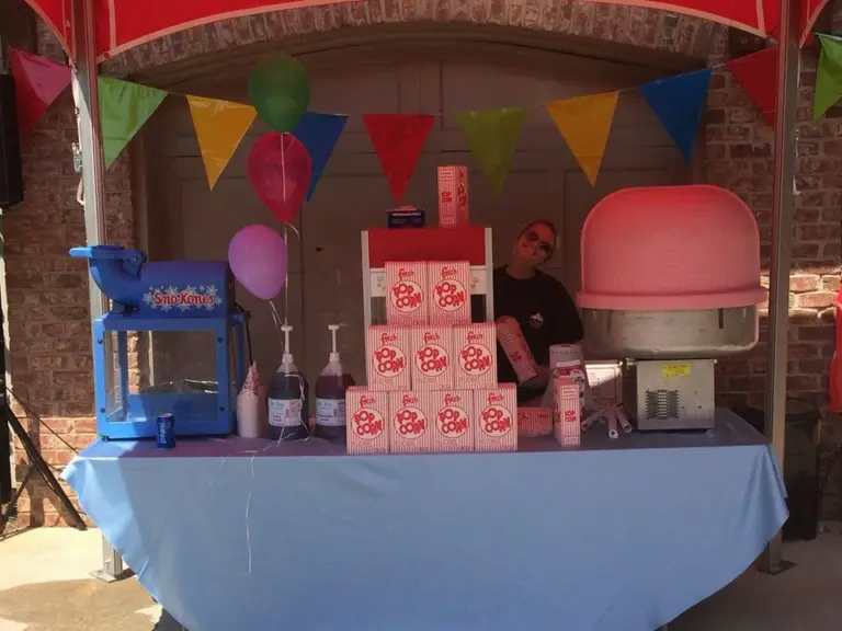 popcorn and cotton candy being served under a tent