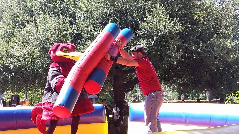 College students battling on the inflatable joust game, rented from Will & Kris